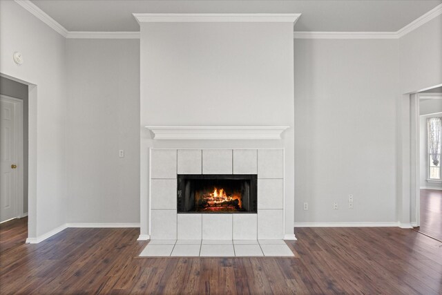 room details featuring a tiled fireplace, crown molding, and hardwood / wood-style flooring