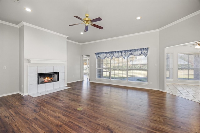 unfurnished living room featuring a tile fireplace, wood-type flooring, a healthy amount of sunlight, and ceiling fan