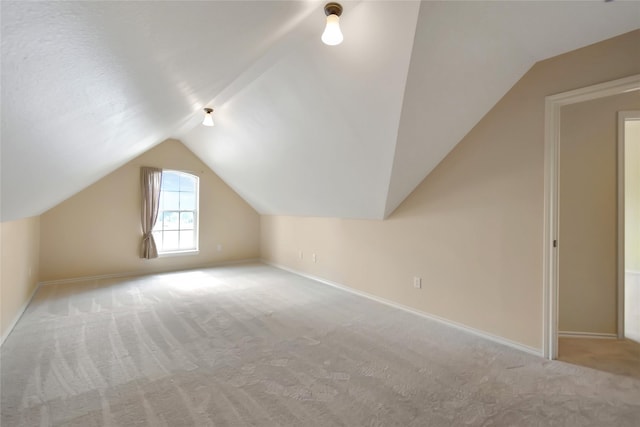 bonus room with light colored carpet and lofted ceiling