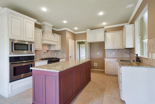 kitchen featuring white cabinets, sink, a kitchen island, and stainless steel appliances