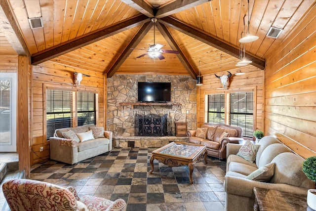 living room with wood walls, a healthy amount of sunlight, a stone fireplace, and wooden ceiling