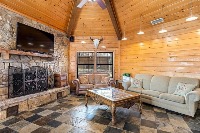 living room with wooden walls, a fireplace, beamed ceiling, and wooden ceiling