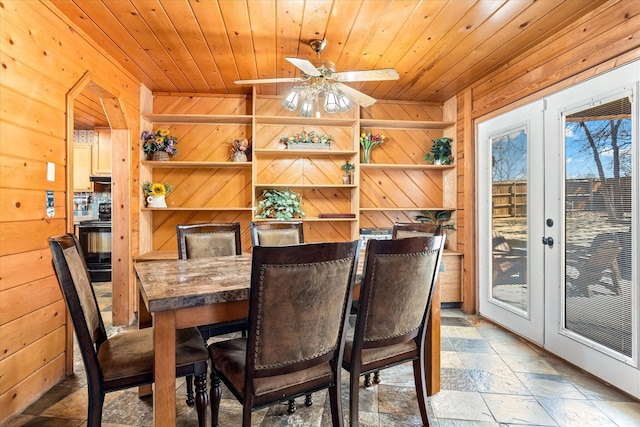 dining space with wood walls, french doors, and wooden ceiling