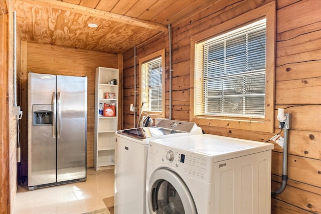 clothes washing area featuring washer and clothes dryer, wood walls, and wood ceiling