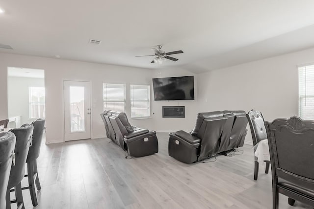 living room with ceiling fan, plenty of natural light, and light hardwood / wood-style flooring