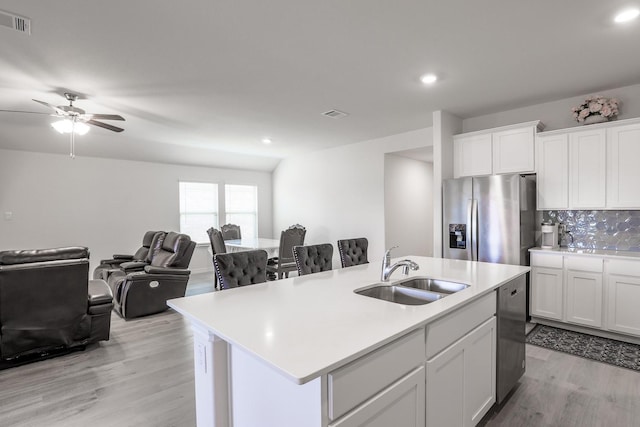 kitchen featuring appliances with stainless steel finishes, white cabinetry, a kitchen island with sink, and sink