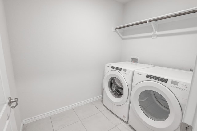 laundry room with washing machine and dryer and light tile patterned floors