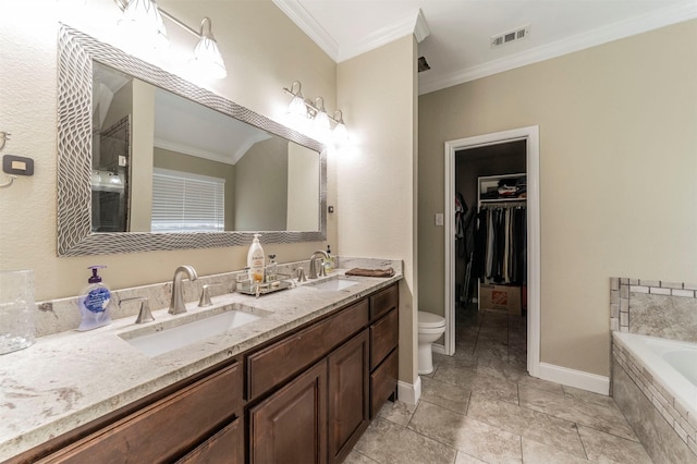 bathroom with tiled tub, crown molding, vanity, and toilet