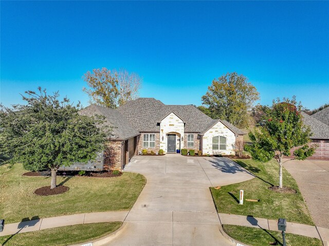 french provincial home featuring a front lawn