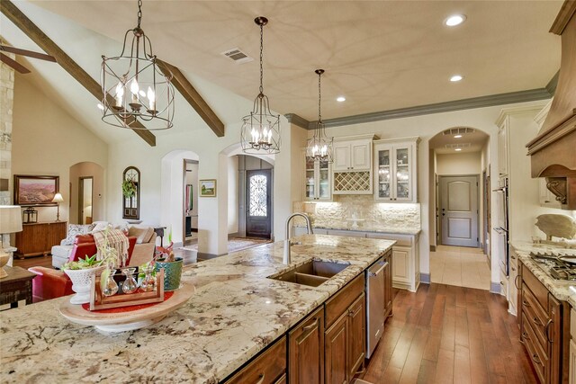 kitchen with pendant lighting, vaulted ceiling with beams, dark wood-type flooring, and sink