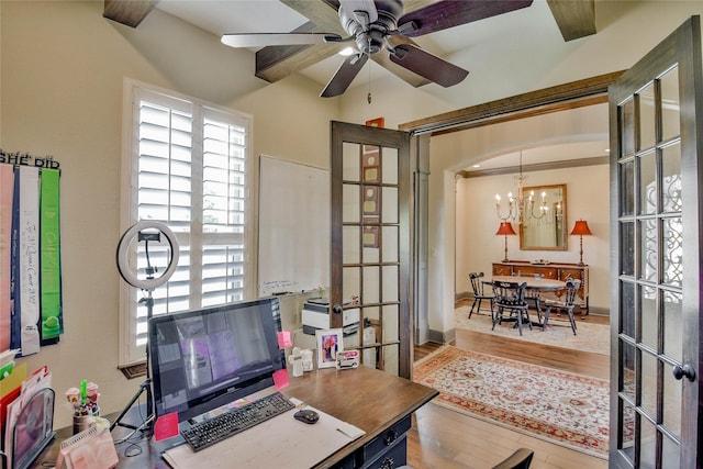 office space with ceiling fan with notable chandelier, light hardwood / wood-style flooring, a wealth of natural light, and ornamental molding