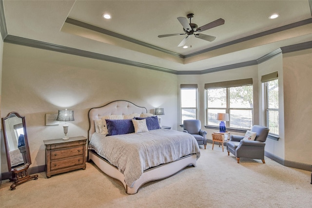 bedroom with ceiling fan, light colored carpet, ornamental molding, and a tray ceiling