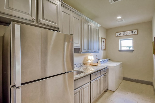 washroom with washer and clothes dryer, light tile patterned floors, and sink