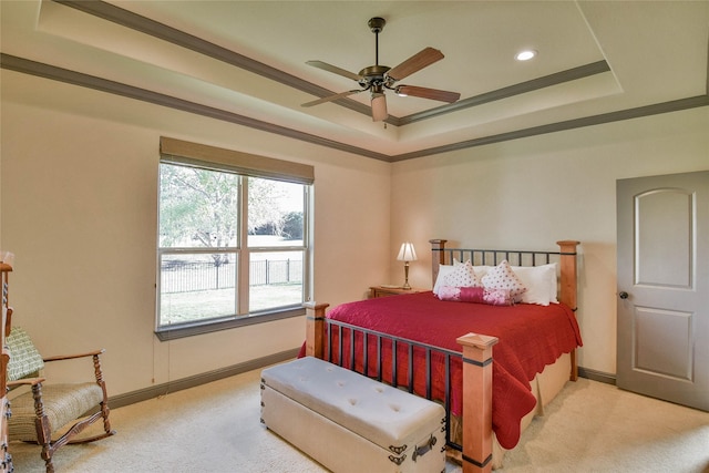 carpeted bedroom featuring a tray ceiling, ceiling fan, and crown molding