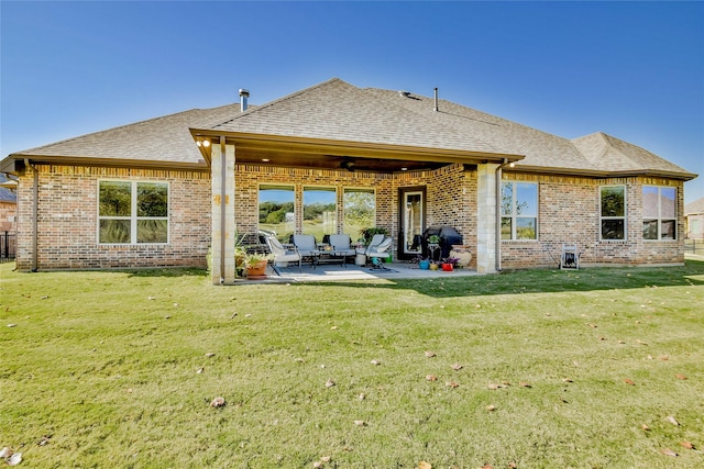 rear view of property with a lawn, ceiling fan, and a patio