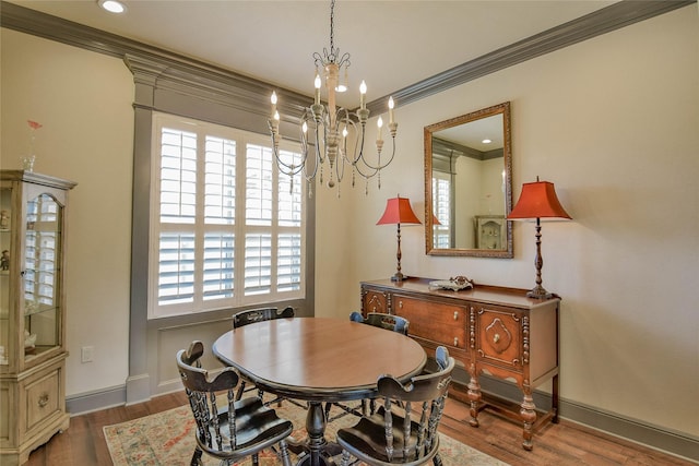 dining space featuring dark hardwood / wood-style flooring, a notable chandelier, and ornamental molding