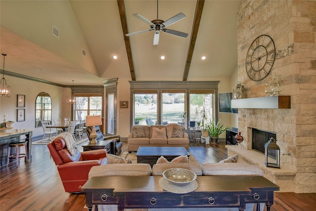 living room with a stone fireplace, wood-type flooring, and high vaulted ceiling