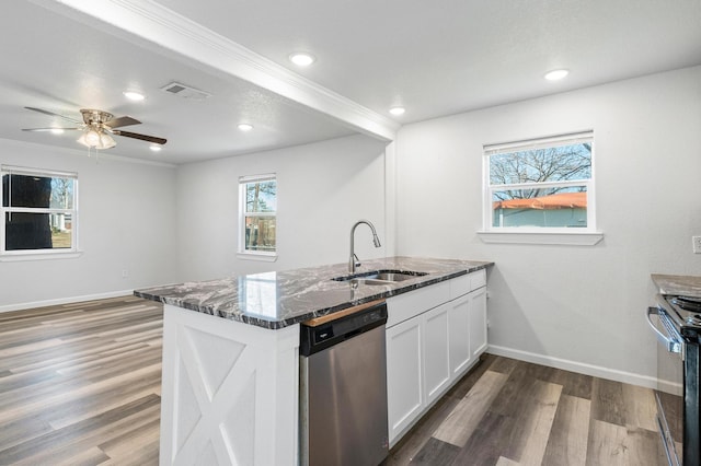 kitchen with sink, dark stone countertops, range with gas stovetop, white cabinets, and stainless steel dishwasher