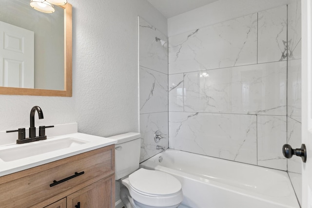 full bathroom featuring tiled shower / bath combo, vanity, and toilet