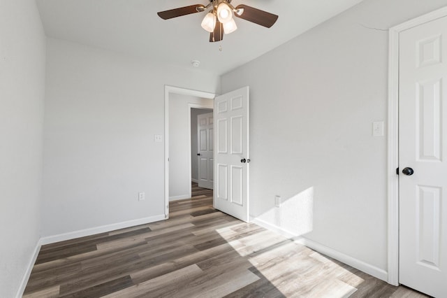 unfurnished bedroom featuring dark wood-type flooring and ceiling fan