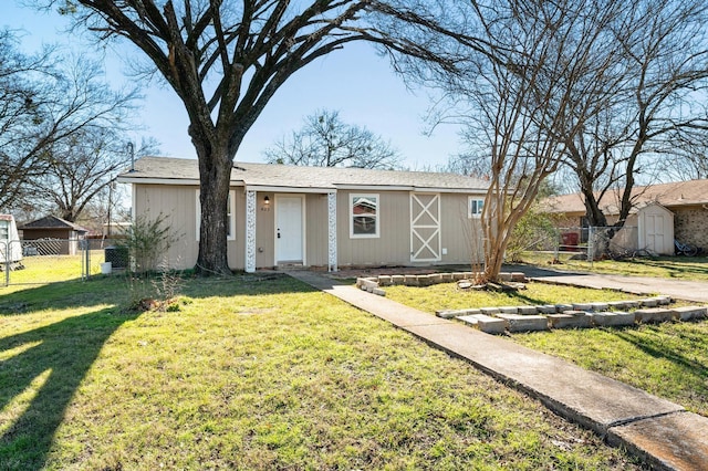 view of front of property featuring a storage unit and a front yard