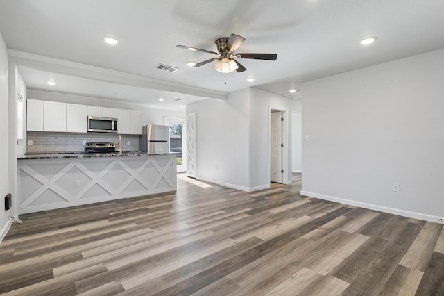 unfurnished living room featuring wood-type flooring and ceiling fan