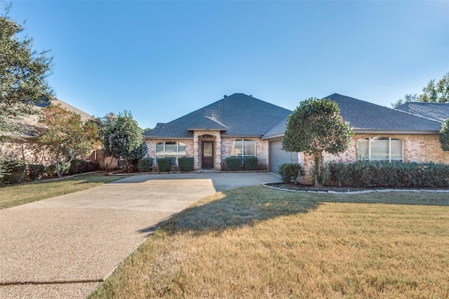 view of front of property with a garage and a front lawn