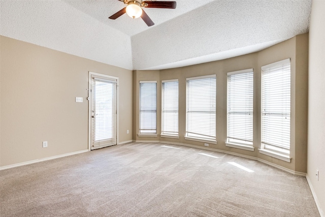 empty room with ceiling fan, light colored carpet, a healthy amount of sunlight, and a textured ceiling