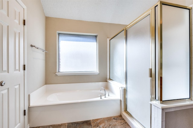 bathroom with plus walk in shower and a textured ceiling