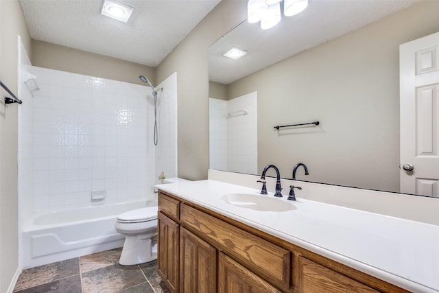 full bathroom featuring vanity, tiled shower / bath combo, a textured ceiling, and toilet