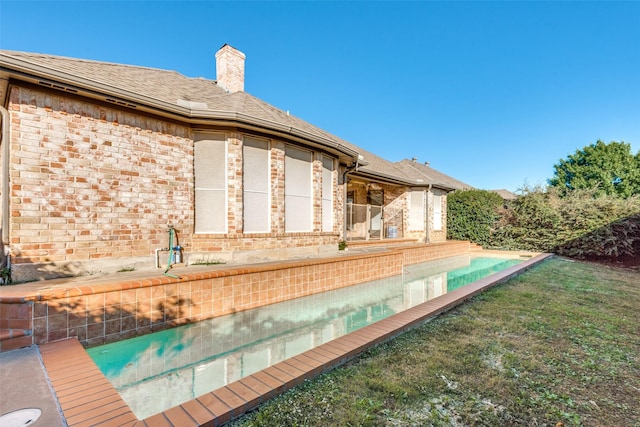 view of swimming pool with a lawn