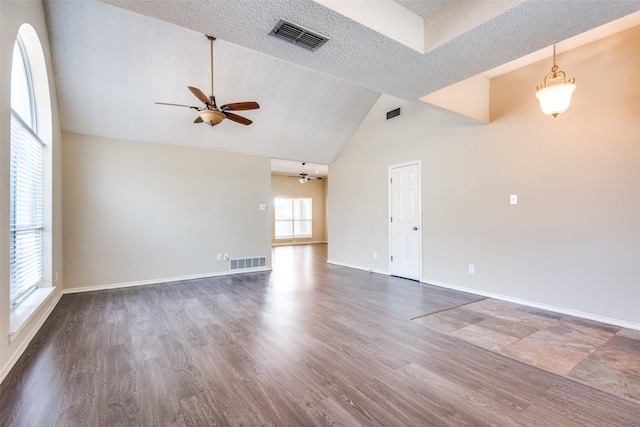 spare room featuring a textured ceiling, dark hardwood / wood-style floors, high vaulted ceiling, and ceiling fan