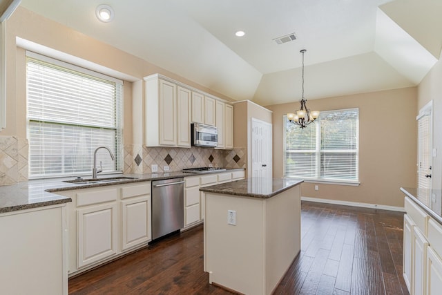 kitchen featuring a center island, lofted ceiling, sink, appliances with stainless steel finishes, and dark hardwood / wood-style flooring