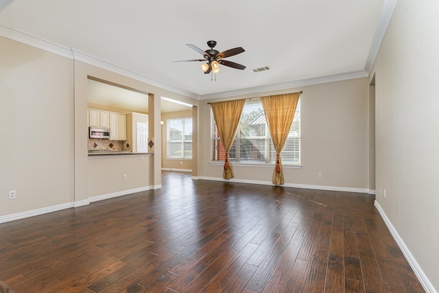 empty room featuring dark hardwood / wood-style flooring, ornamental molding, and ceiling fan