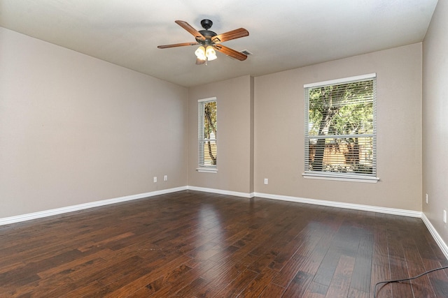 empty room with ceiling fan, a healthy amount of sunlight, and dark hardwood / wood-style flooring