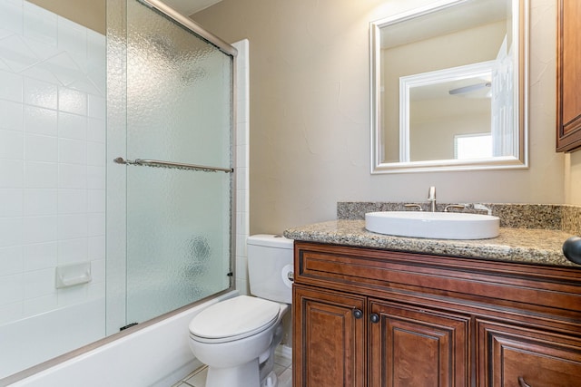 full bathroom featuring tile patterned floors, vanity, toilet, and enclosed tub / shower combo