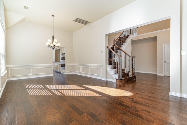 interior space with dark wood-type flooring, lofted ceiling, and an inviting chandelier