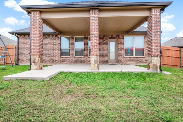 rear view of house featuring a yard and a patio