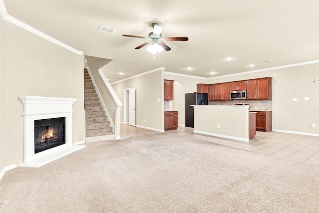 unfurnished living room with ceiling fan, light tile patterned flooring, and ornamental molding