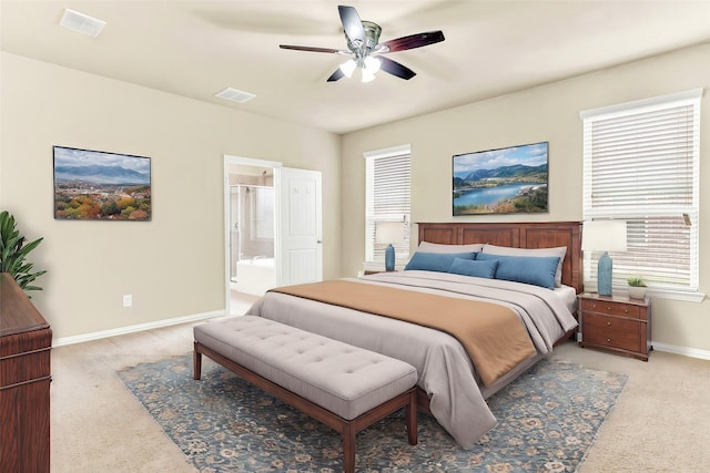 carpeted bedroom with ensuite bathroom and ceiling fan