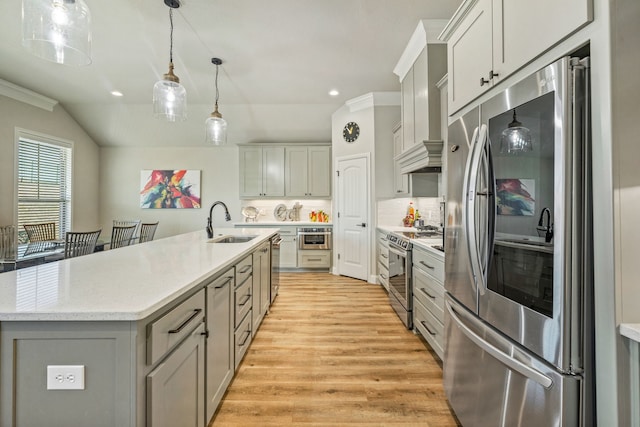 kitchen featuring appliances with stainless steel finishes, sink, gray cabinetry, and decorative light fixtures