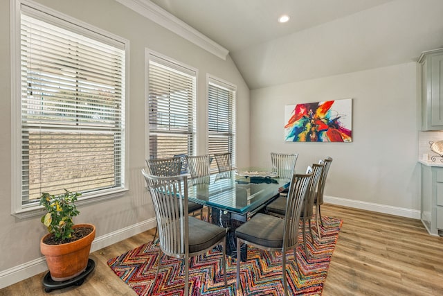 dining area featuring vaulted ceiling and light hardwood / wood-style flooring