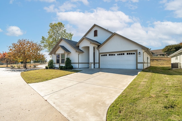 view of front of house with a garage, a front yard, and central AC unit