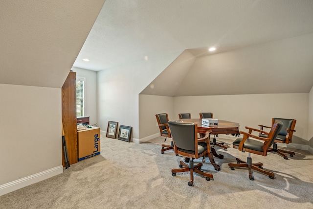 carpeted home office featuring lofted ceiling and a textured ceiling