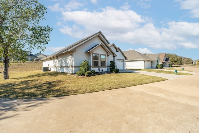 view of front of house with a garage, a front yard, and central air condition unit