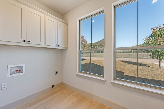 washroom with washer hookup, cabinets, light hardwood / wood-style floors, and hookup for an electric dryer