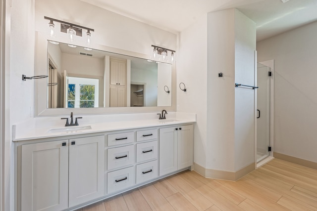 bathroom with vanity, hardwood / wood-style flooring, and a shower with shower door