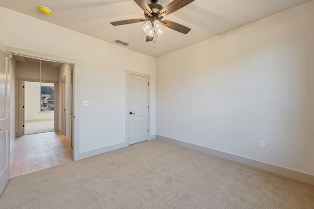 unfurnished bedroom with light colored carpet and ceiling fan