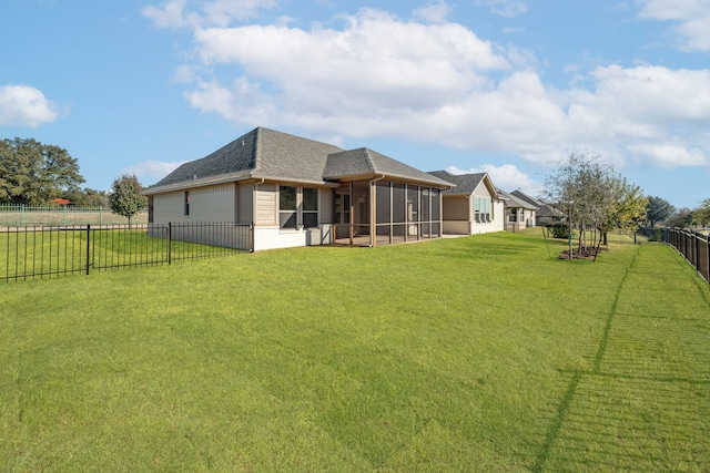 rear view of property featuring a yard and a sunroom