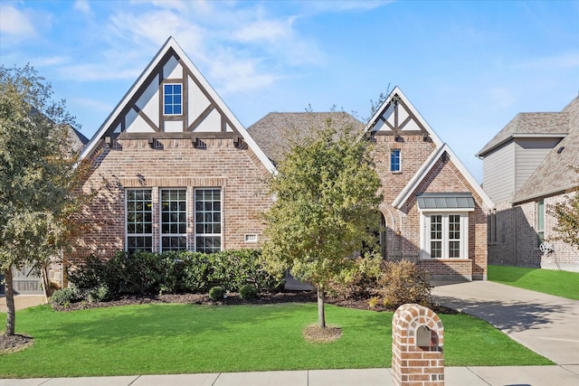 tudor-style house with a front yard